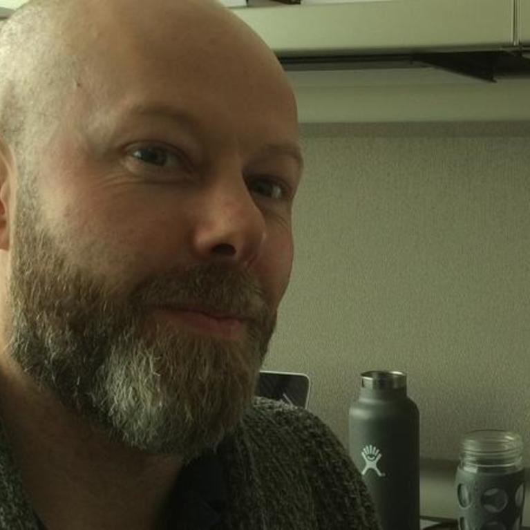 Dr. John Barton posing with a desktop computer.